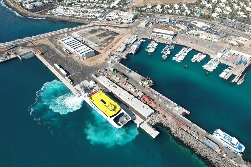 Vista aérea del puerto de Playa Blanca, en Lanzarote, con un ferry en maniobra junto a la terminal.